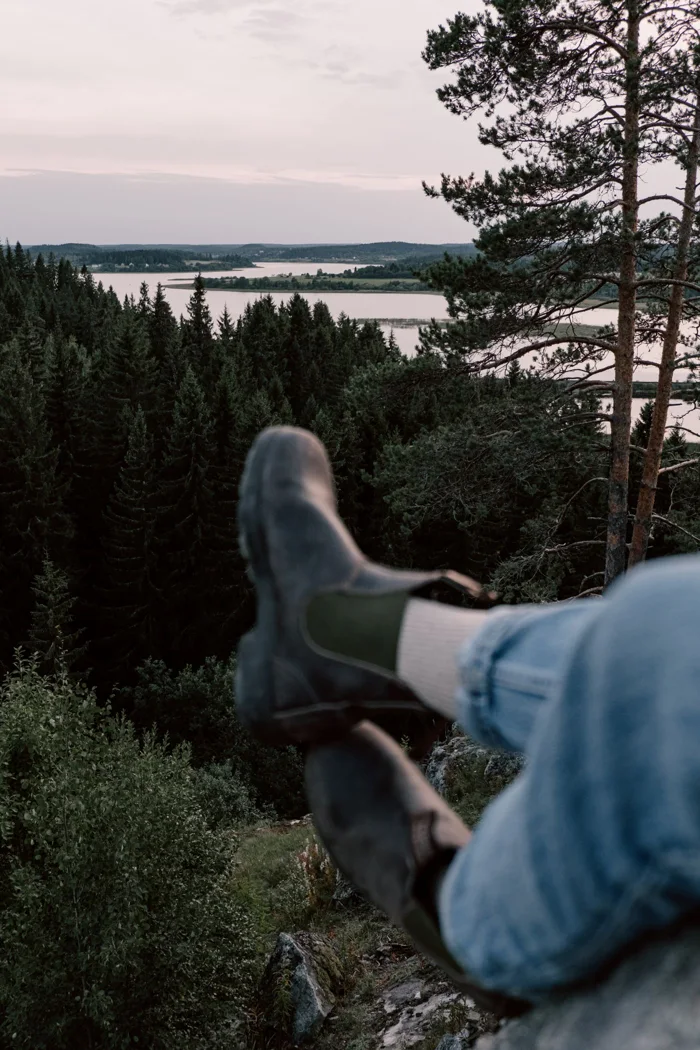 Walking shoes overlooking a wooded landscape.