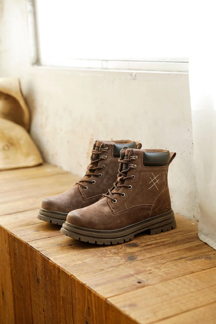 A pair of hiking boots on a wooden bench.