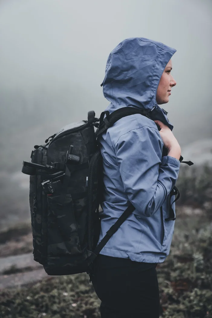 A walker in a hooded jacket with a backpack in mist.
