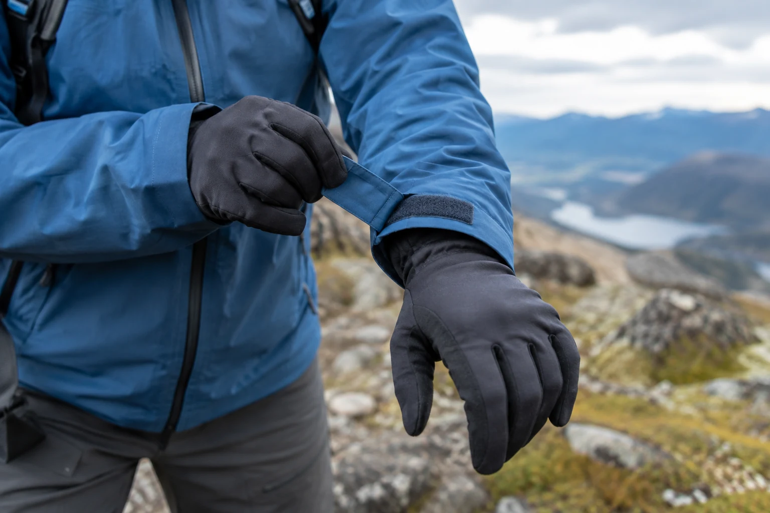 A shell-jacket cuff overlapping a thin glove.