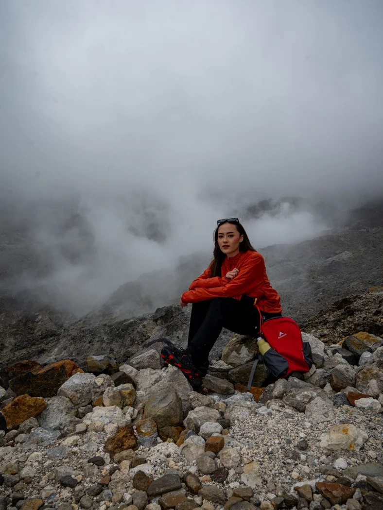 Bright outerwear in a misty landscape.