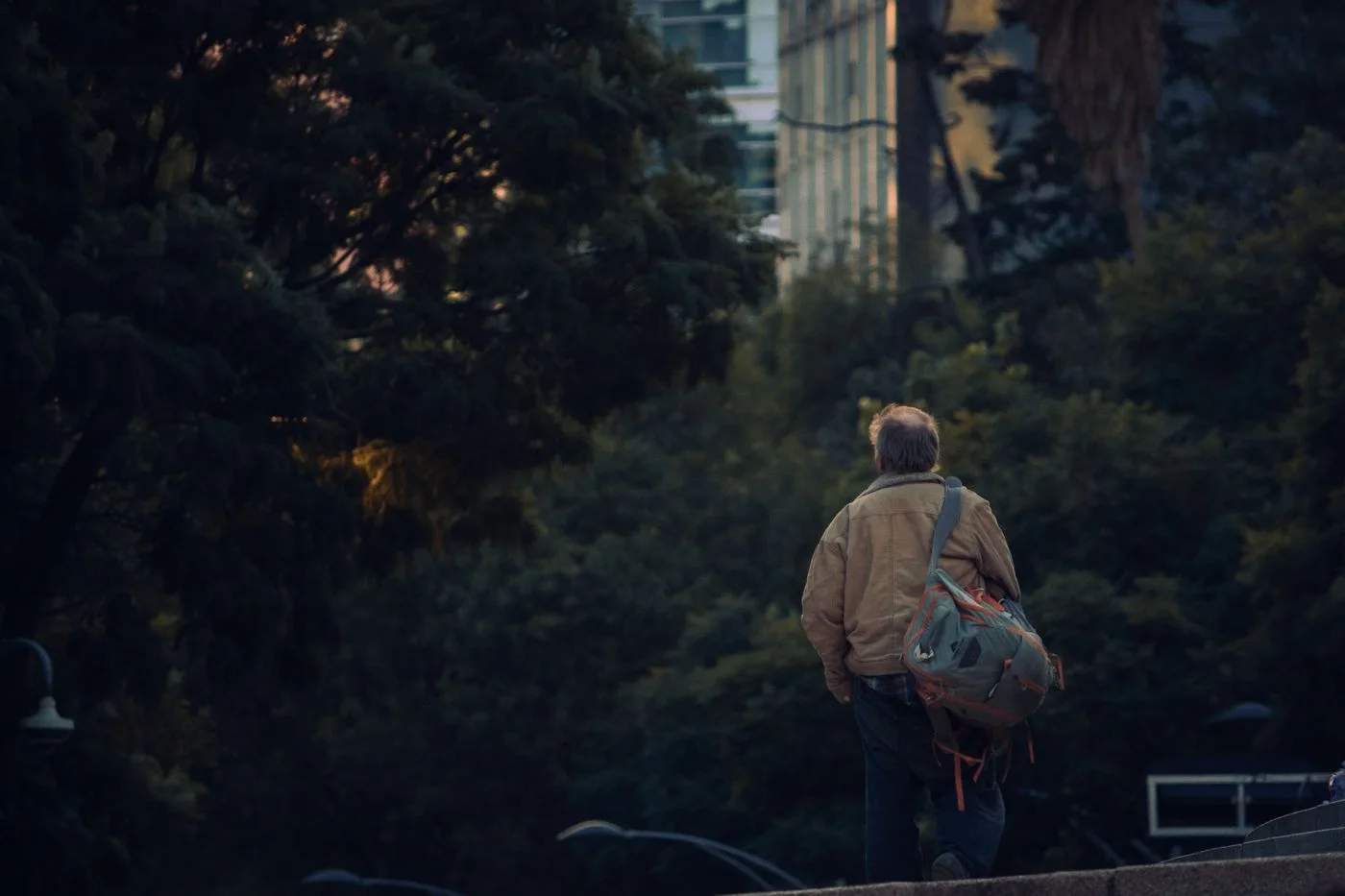 A person with a backpack on an urban path.