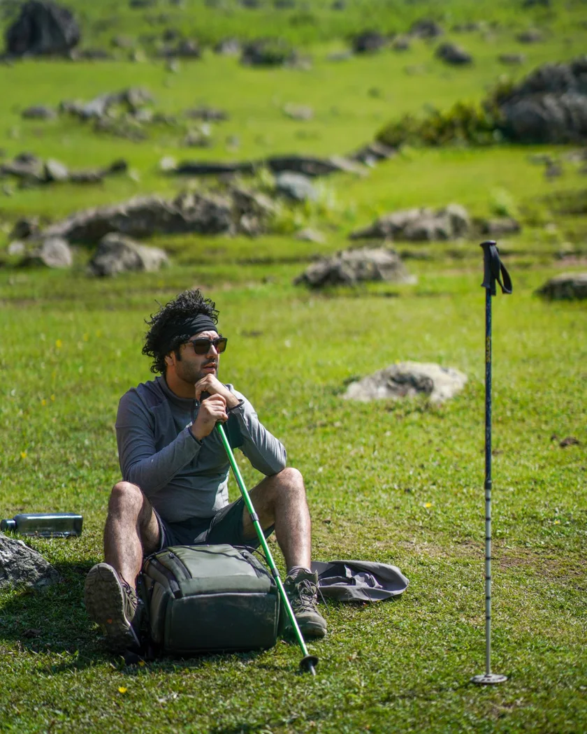 Trekking poles beside a backpack during a break.