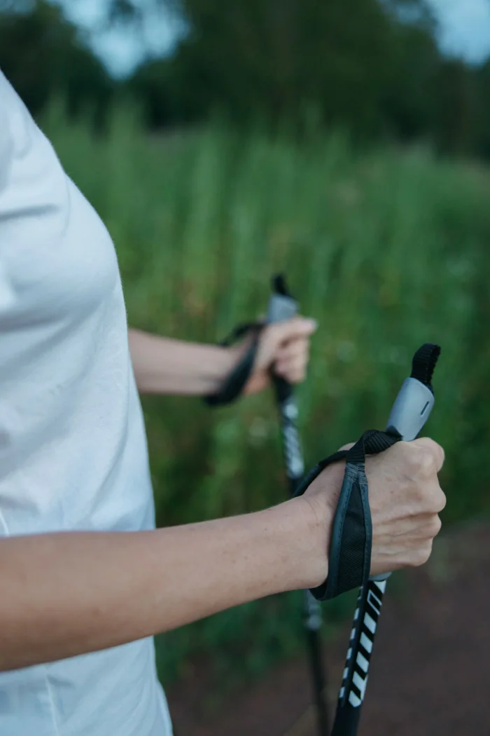Hands holding two trekking-pole grips.