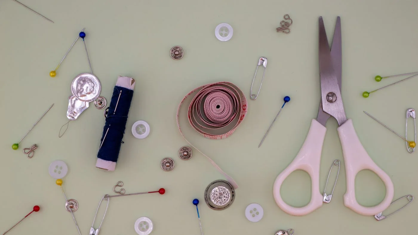 Needle, thread and scissors for small repairs.