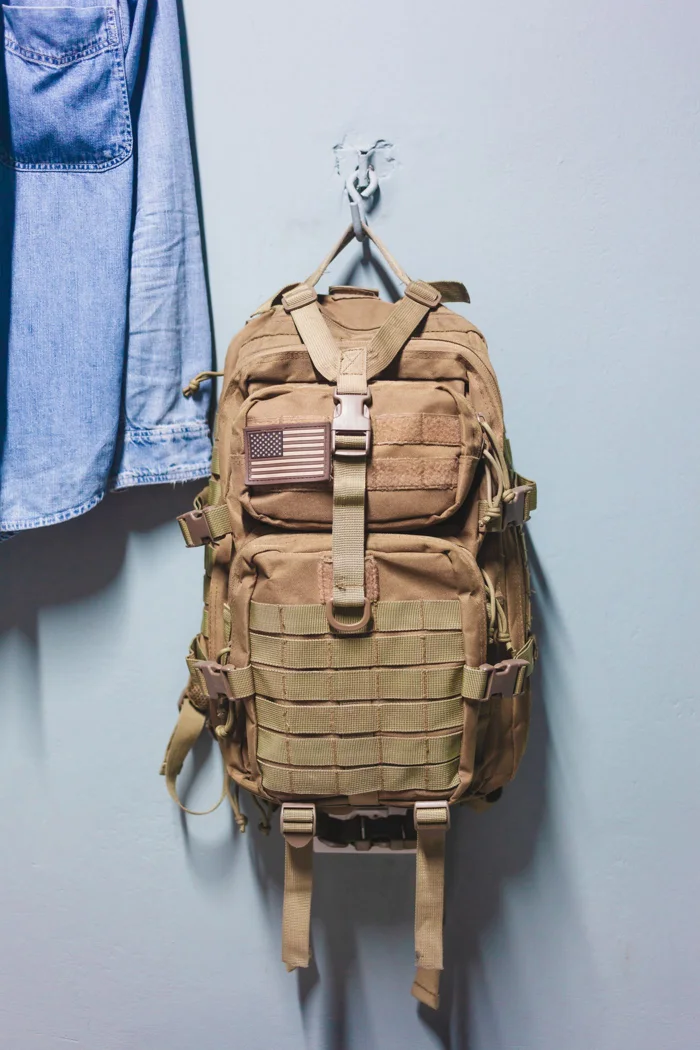 A backpack hanging on a hook for storage.