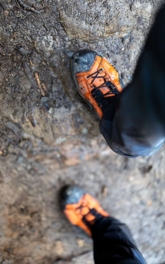 Muddy textile hiking shoes on a path.
