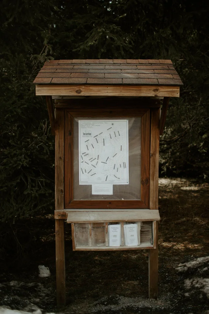 An information board beside a woodland path.