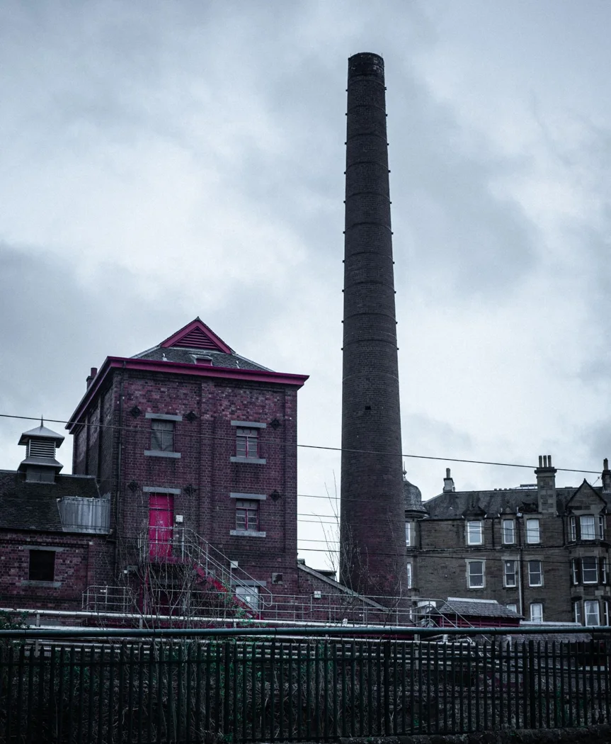 An old factory building with a tall chimney.